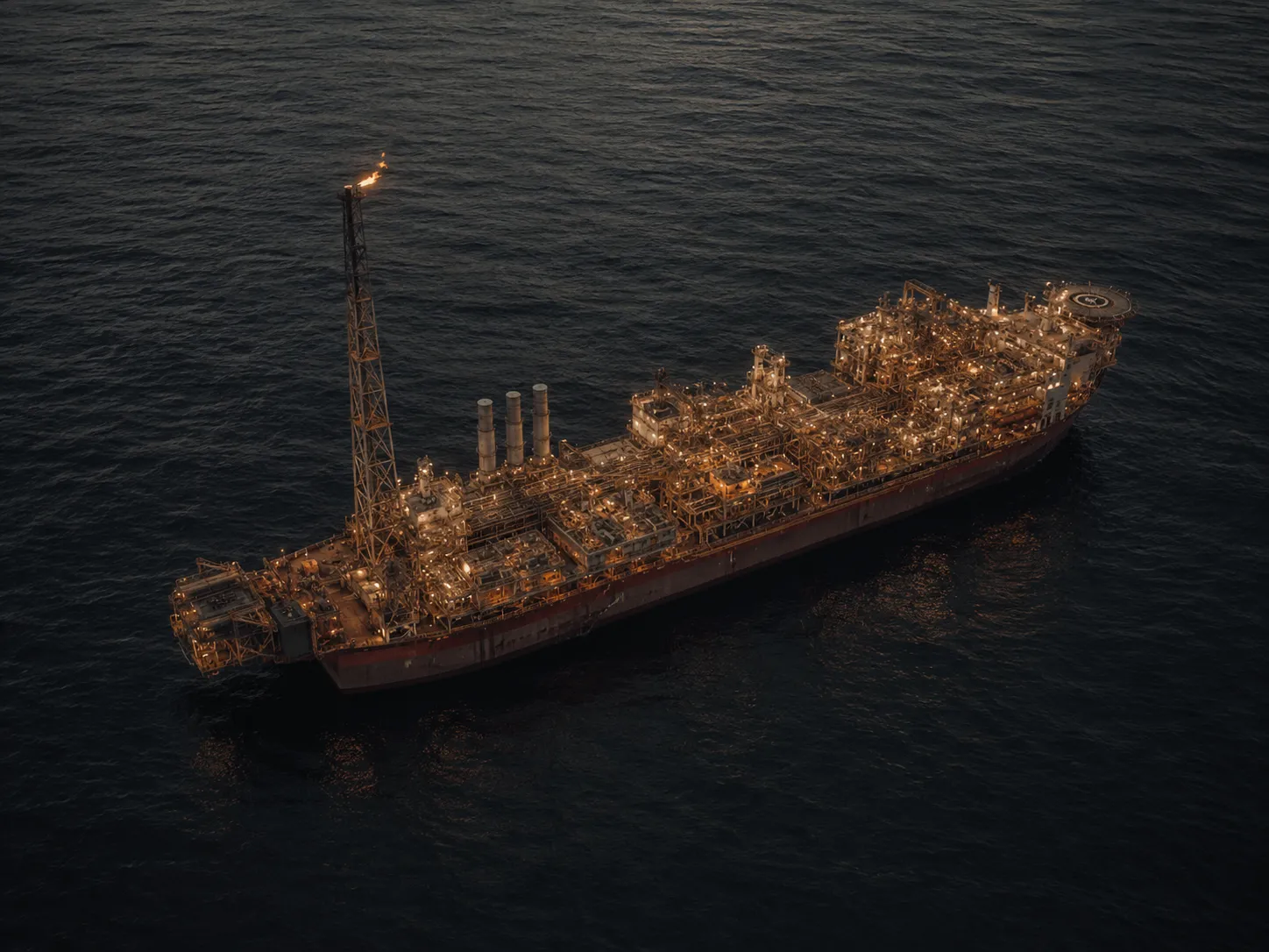 Aerial view of an FPSO vessel at sea with dense topside process equipment